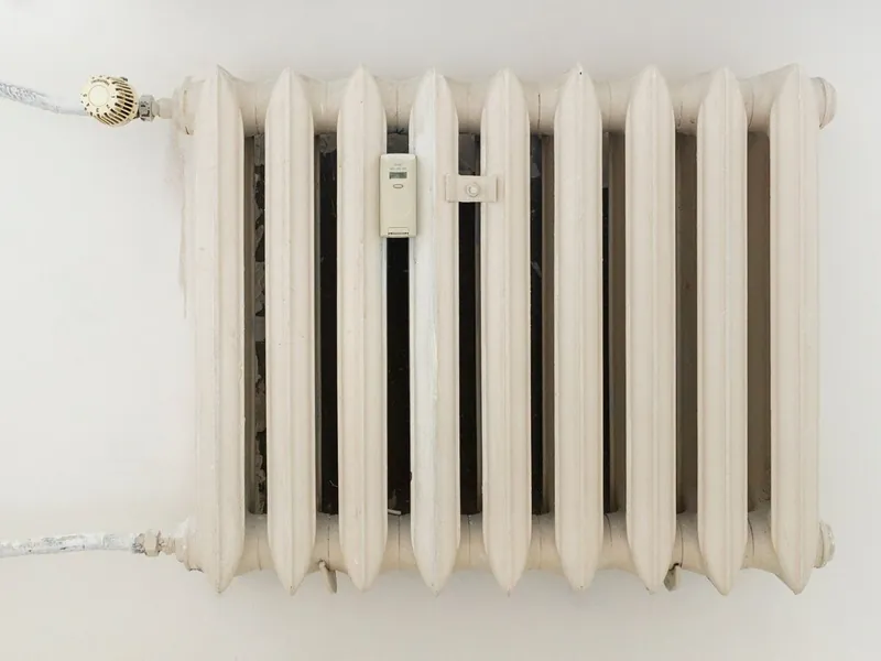 Radiador de hierro fundido instalado en una pared clara